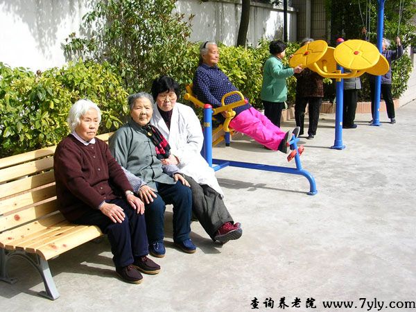 上海恩光敬老院工作人员陪老人在室外晒太阳