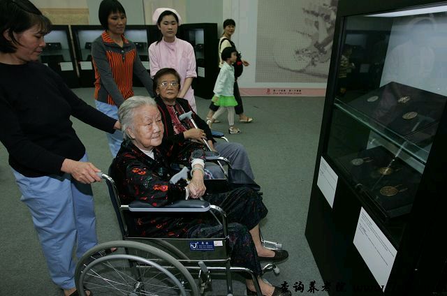 广州市虹桥老人托养中心护工带着老人看奖牌